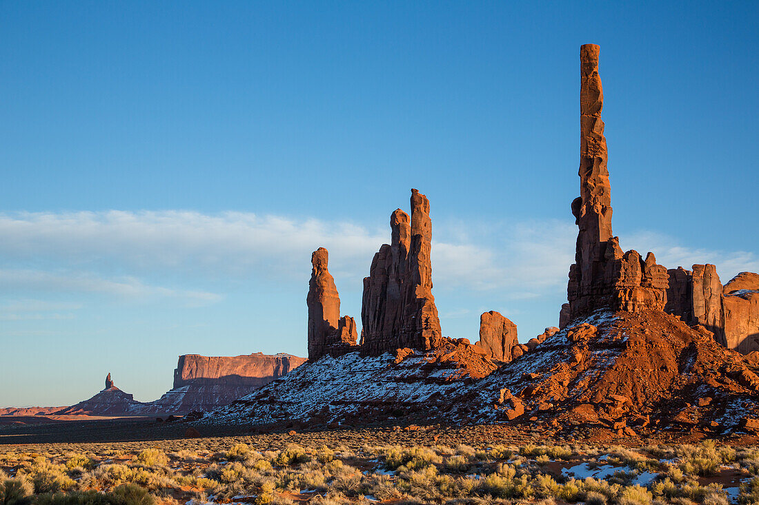 The Totem Pole, Yei Bi Chei and Rooster Rock with rippled sand in the Monument Valley Navajo Tribal Park in Arizona.