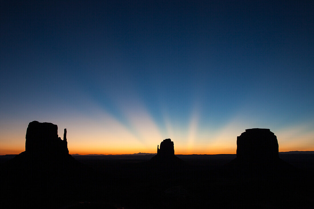 Dämmerungsstrahlen über der Mittens & Merrick Butte vor Sonnenaufgang im Monument Valley Navajo Tribal Park in Arizona