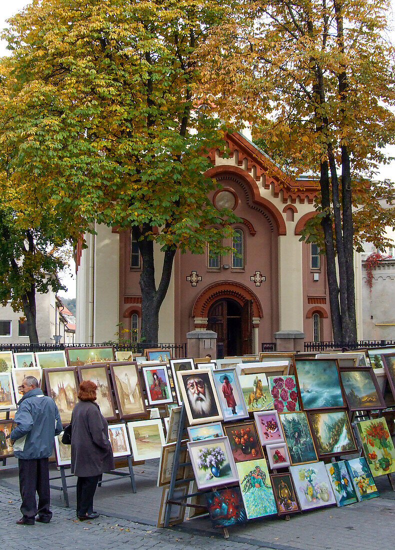 People shop for art in a street market in front of the Church of St. Paraskeva in the Old Town of Vilnius, Lithuania. A UNESCO World Heritage Site. St. Paraskeva is the oldest Eastern Orthodox church in Vilnius.