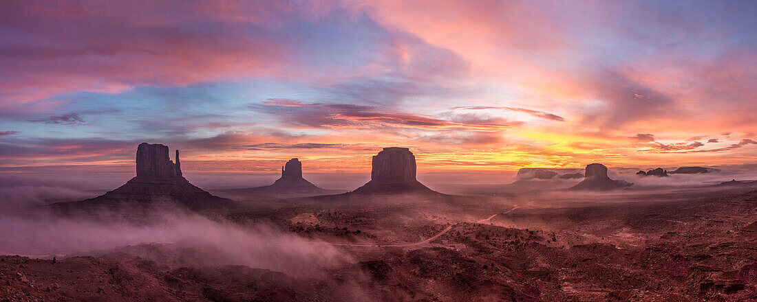 Farbenfroher Sonnenaufgang mit Bodennebel im Monument Valley Navajo Tribal Park in Arizona