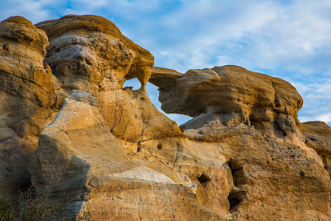 Blue sky and clouds over Graceful Arch in a remote desert near Aztec in northwestern New Mexico.