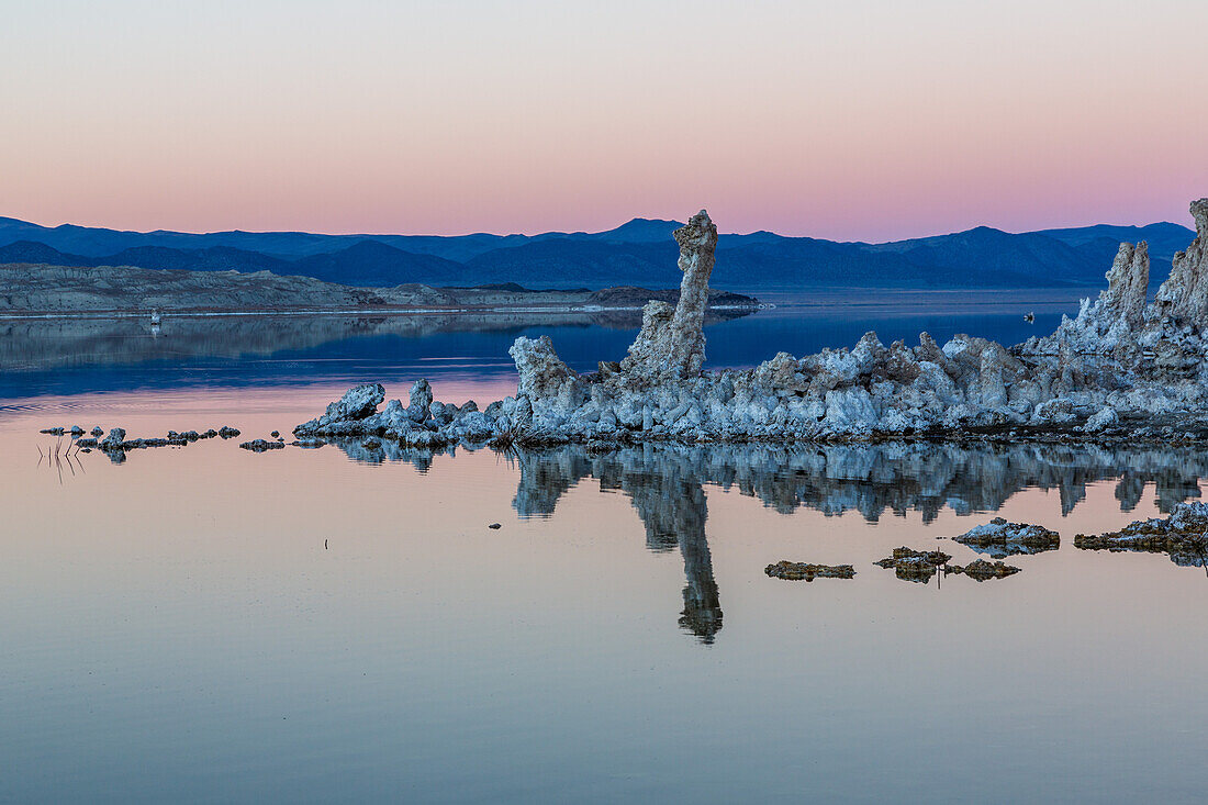 Tufa formations reflected in Mono Lake in California in evening twilight.