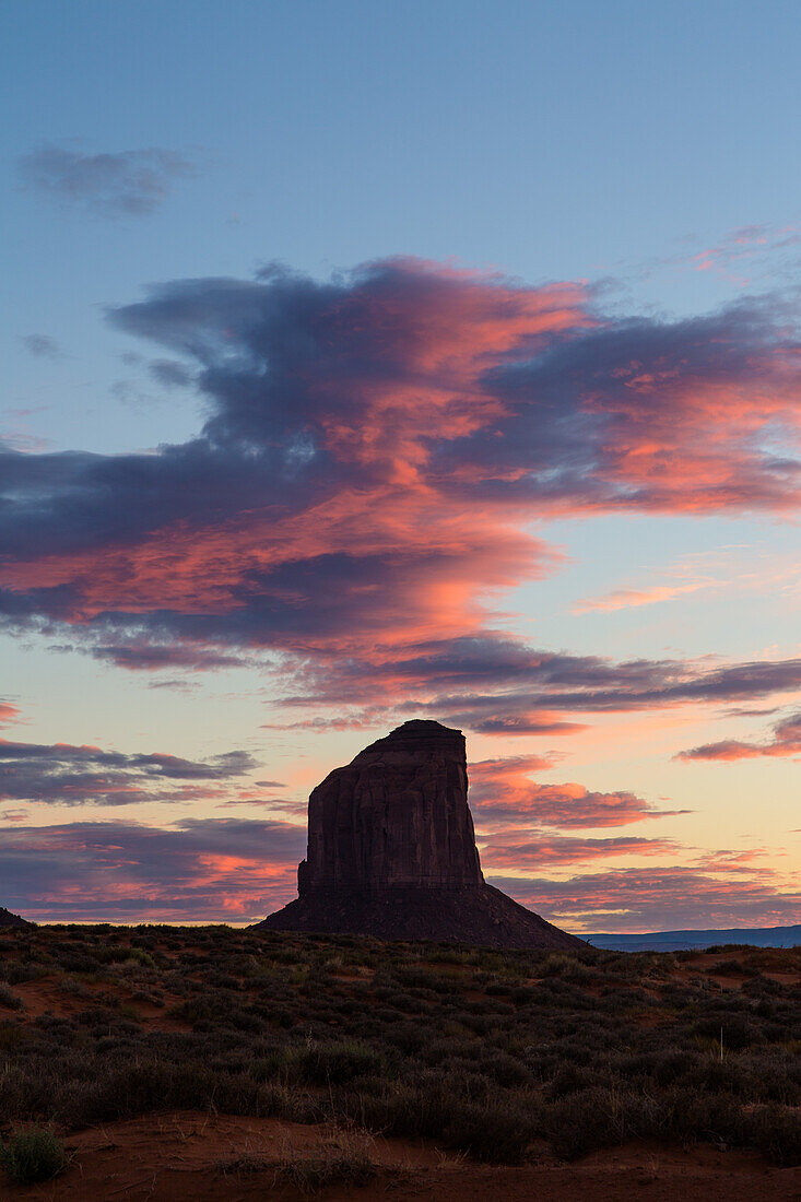 Bunte Wolken über dem Grey Whiskers Butte bei Sonnenuntergang im Monument Valley Navajo Tribal Park in Arizona