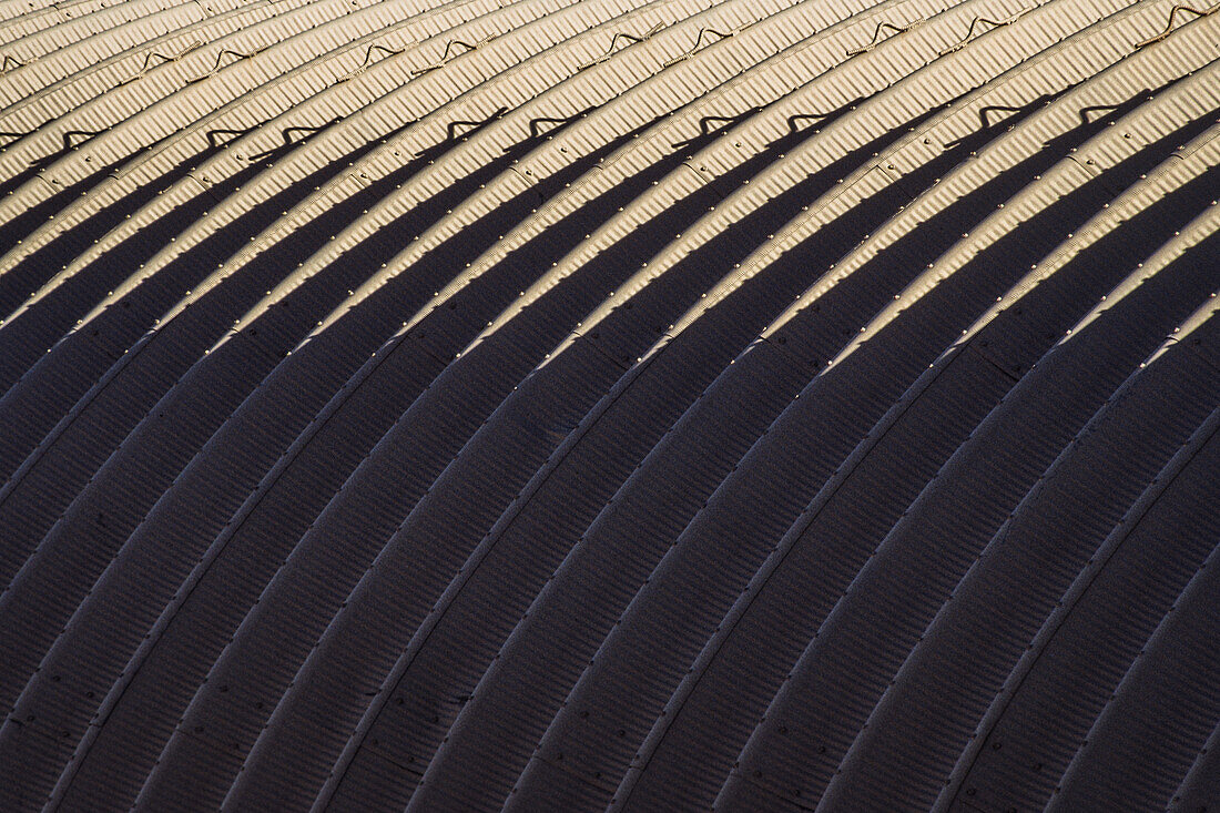 Ein abstraktes Bild mit Licht und Schatten und sich wiederholenden Formen auf einem industriellen Lagergebäude in Texas