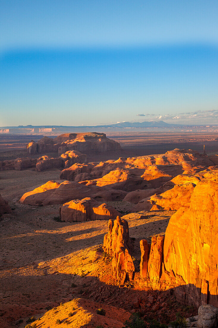 Sunset light on the sandstone formations in the Monument Navajo Valley Tribal Park in Arizona. View from Hunt's Mesa. The Abajo Mountains and the Bear's Ears, left, in the distance.