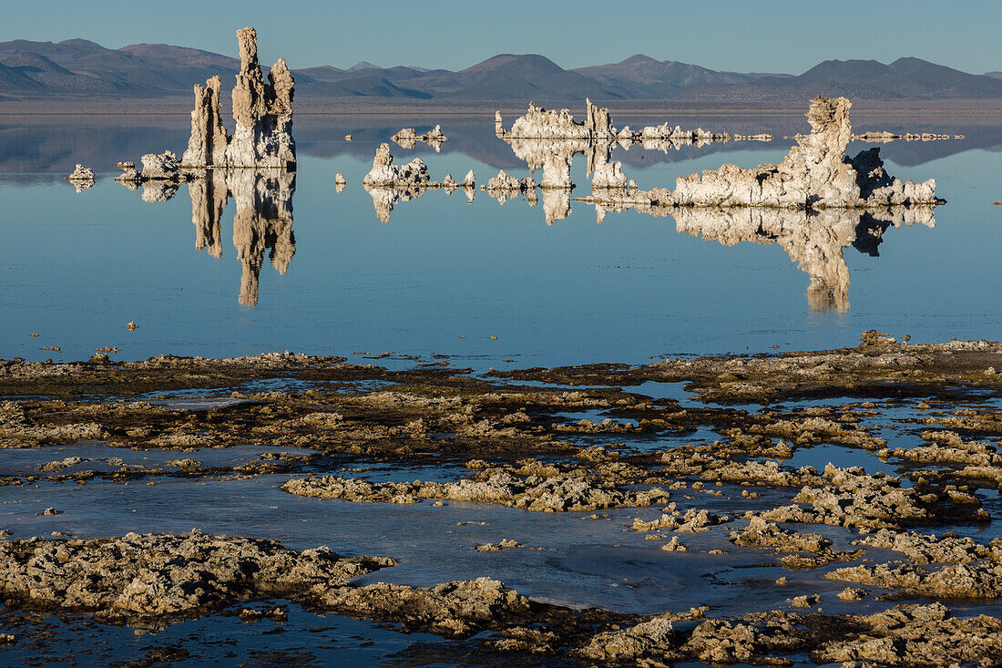 Tufa rock formations reflected in Mono Lake in California.