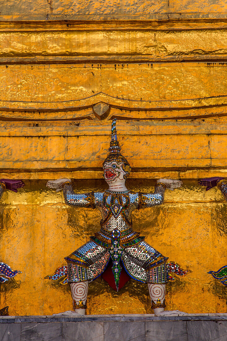 A small yaksha guardian statue at the Temple of the Emerald Buddha complex in the Grand Palace grounds in Bangkok, Thailand. A yaksha or yak is a giant guardian spirit in Thai lore.