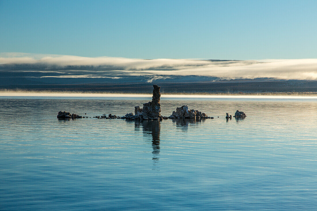 Tufa formations in Mono Lake in California at sunrise with fog in the background.