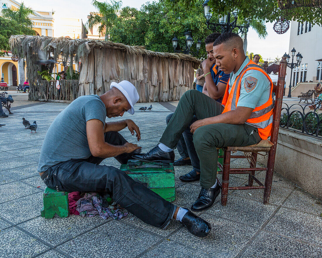 A man getting a shoe shine in Independence Square in Puerto Plata in the Dominican Repbulic.