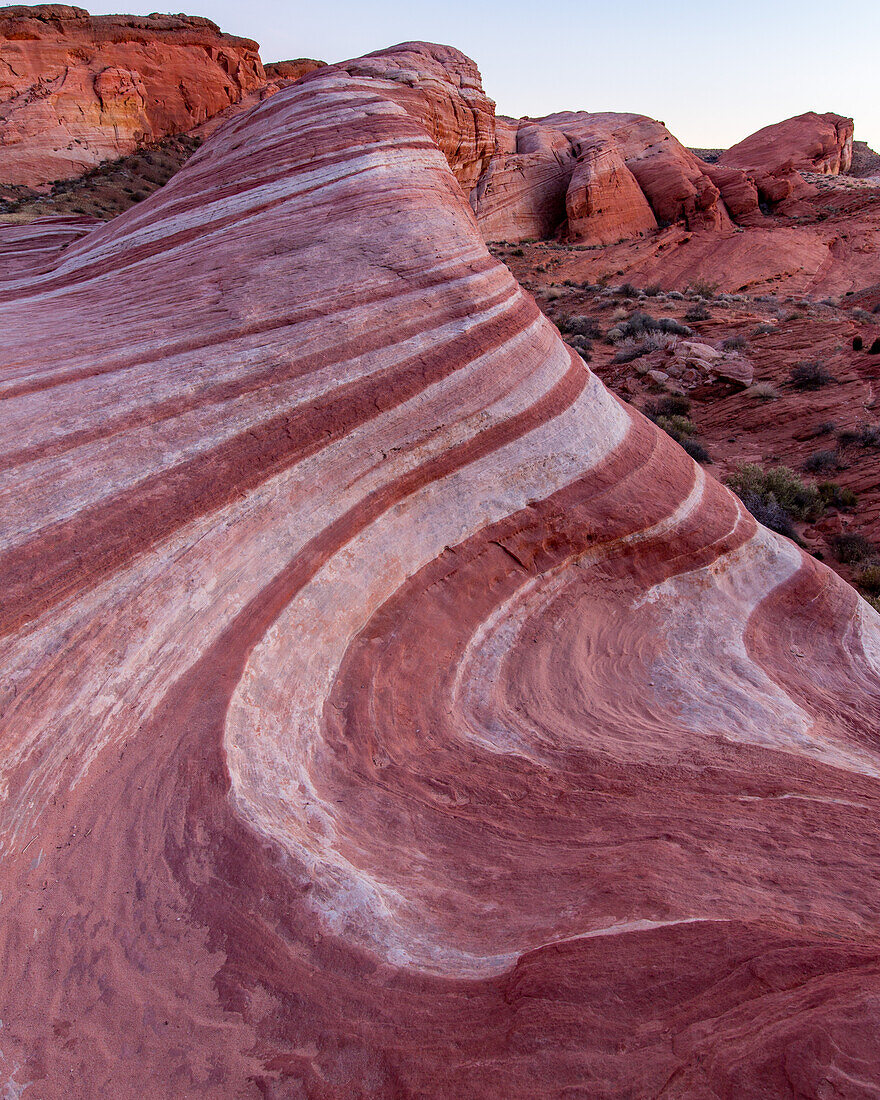 The Fire Wave, a red & white striped Aztec sandstone formation in pastel light after sunset in Valley of Fire State Park, Nevada.