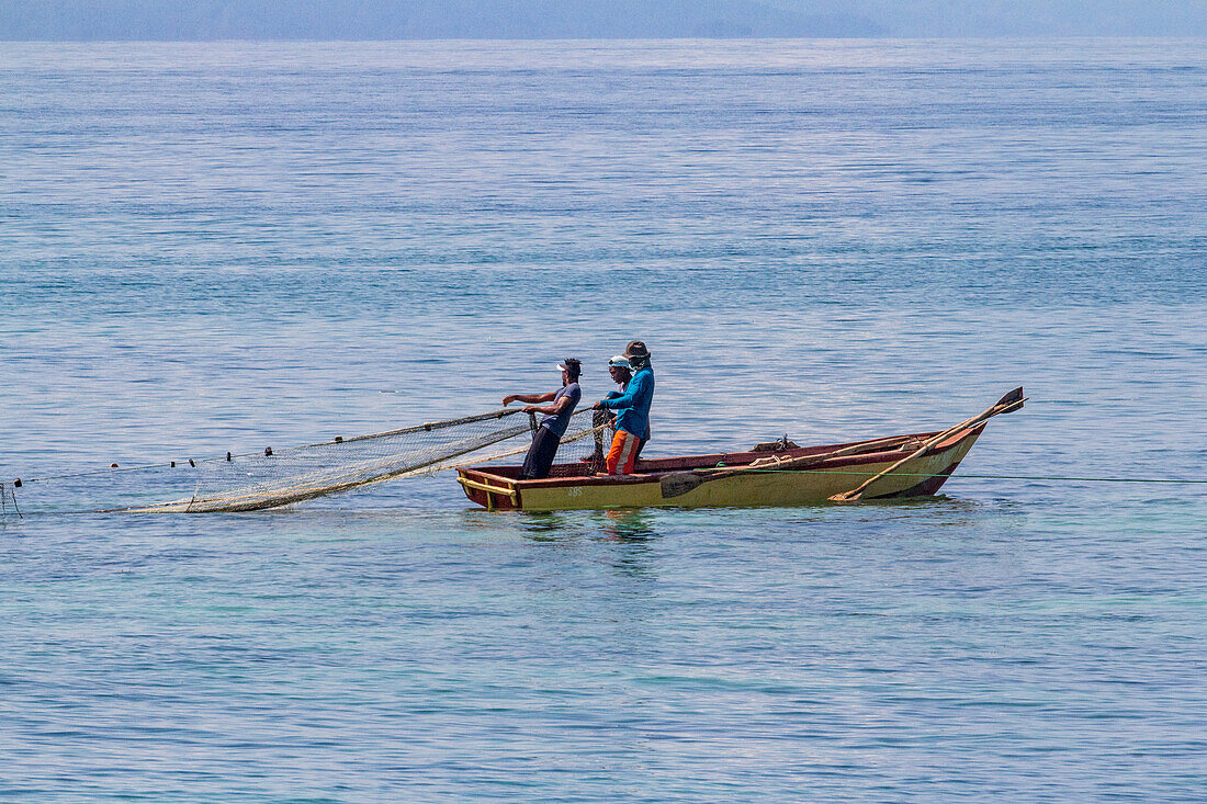 Fishermen pull in their net on a boat in the Bay of Samana in the Dominican Republic.