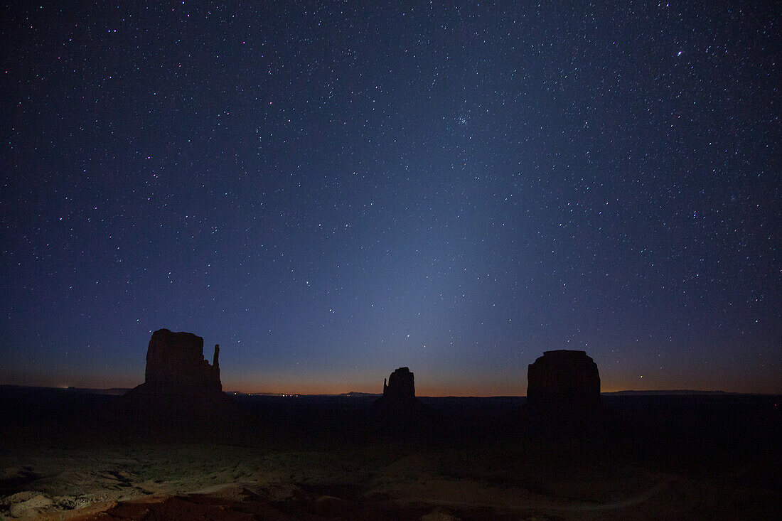 Zodiacal light before dawn over the Mittens and Merrick Butte in the Monument Valley Navajo Tribal Park in Arizona. Zodiacal light is a result of sunlight reflecting off the interplanetary zodiacal dust cloud and is visible around the spring and autumn soltices.