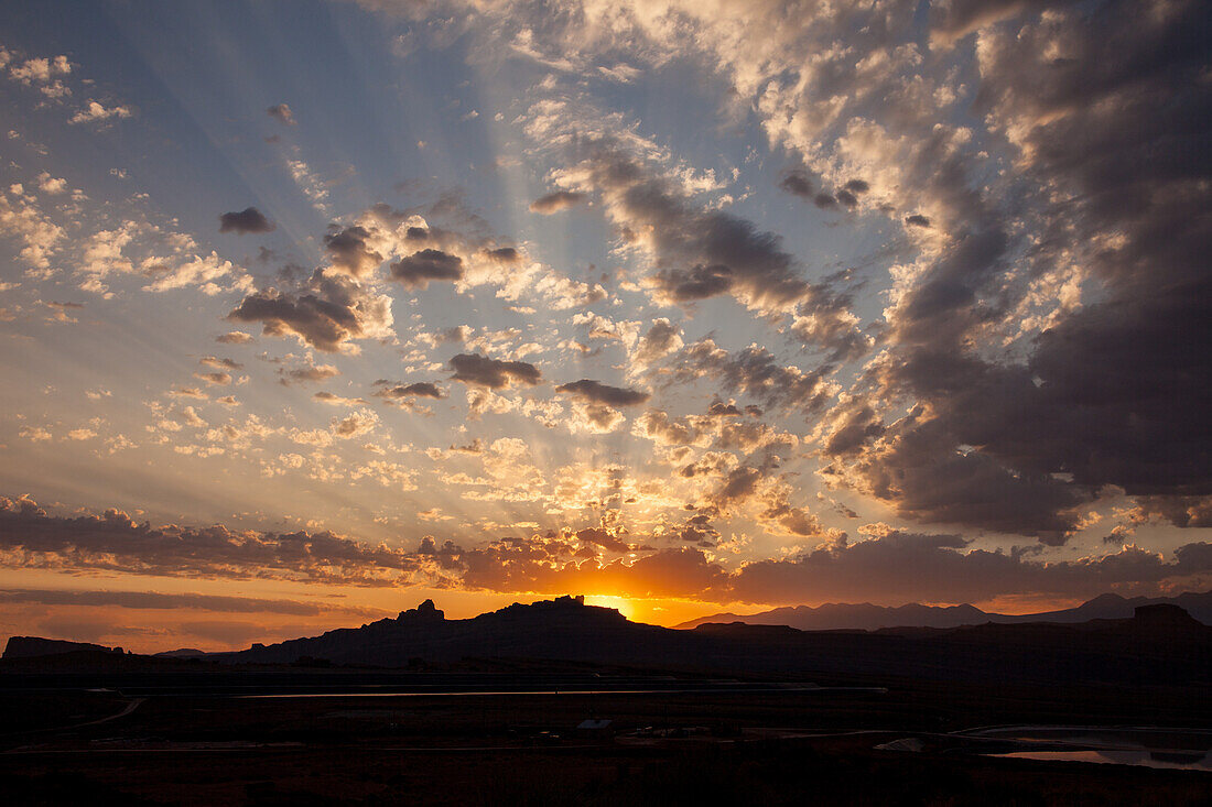 Sonnenaufgangswolken über den La Sal Mountains und der Canyonlandschaft bei Moab, Utah