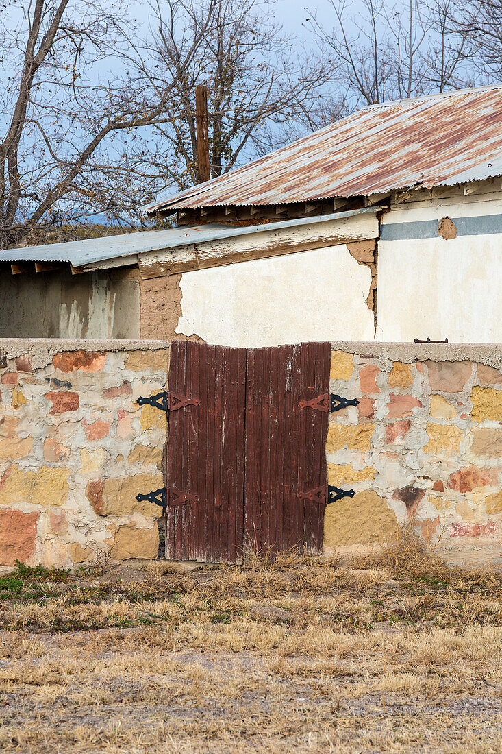Old woden gates in a stone wall in San Antonio, a small town in rural New Mexico.