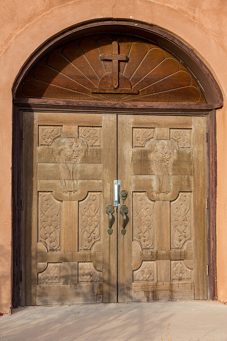Carved wooden doors of the old mission-style Catholic parish church in San Antonio, a small town in rural New Mexico.