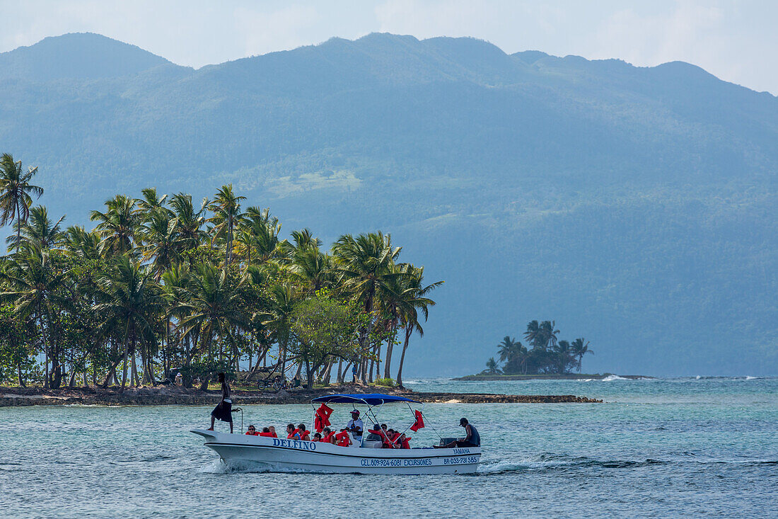 Eine Bootsladung Touristen kehrt von einem Meeresausflug in Bahia de Las Galeras auf der Halbinsel Samana, Dominikanische Republik, zurück