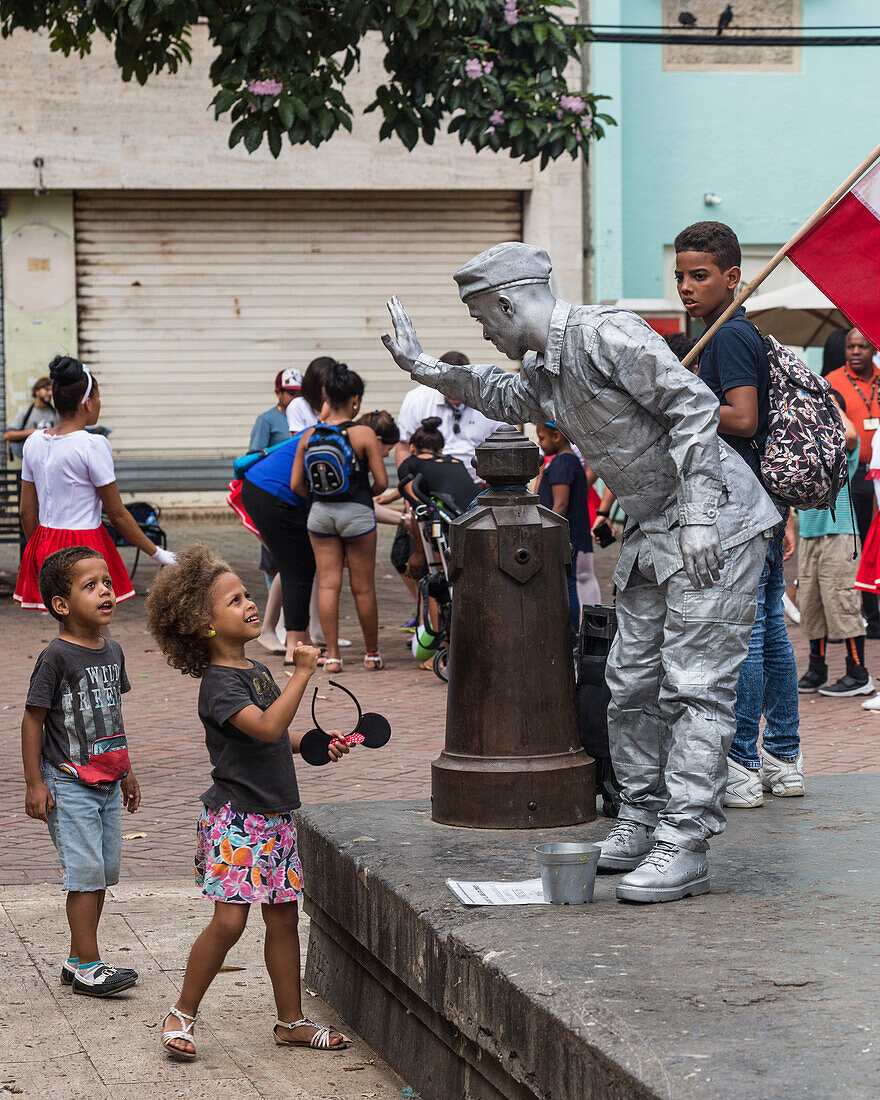 Zwei kleine Kinder beobachten eine Pantomime im kolonialen Sektor von Santo Domingo, Dominikanische Republik