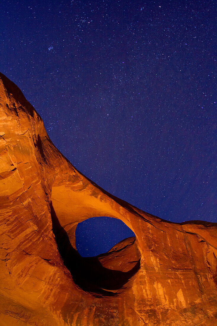 Stars over Moccasin Arch at night in the Monument Valley Navajo Tribal Park in Arizona.