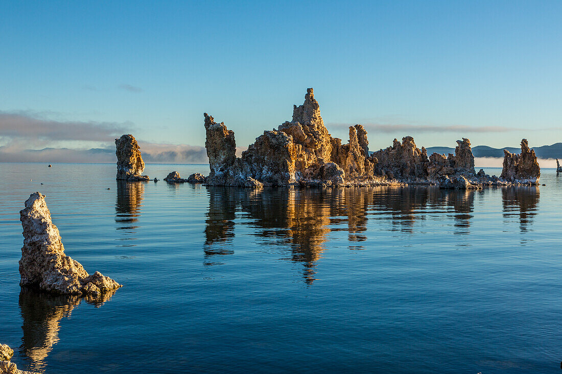 Tufa formations in Mono Lake in California at sunrise with fog in the background.