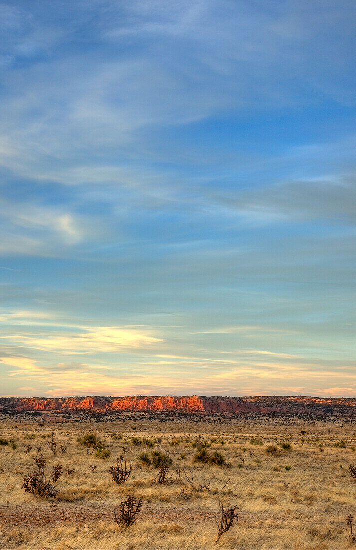 Farbenfrohe Wolken bei Sonnenuntergang über einem Tafelberg in den Hochebenen des östlichen New Mexico