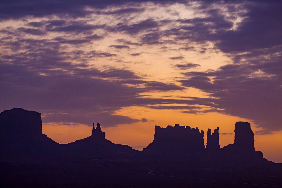 Sonnenaufgangssilhouette der Utah-Monumente im Monument Valley Navajo Tribal Park in Arizona. L-R: Brighams Grab, König auf seinem Thron, die Postkutsche, der Bär und das Kaninchen, Castle Butte und der große Indianerhäuptling. Sie werden oft als Utah-Monumente bezeichnet, weil sie direkt hinter der Grenze in Utah liegen, während der größte Teil des Parks in Arizona liegt.