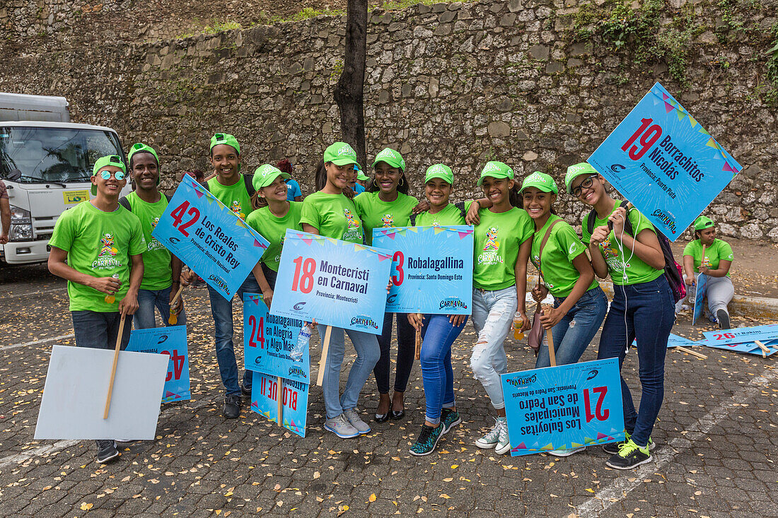 Teilnehmer am Jugendkarnevalsumzug in der Kolonialstadt Santo Domingo mit den Schildern ihrer Gruppen. Dominikanische Republik