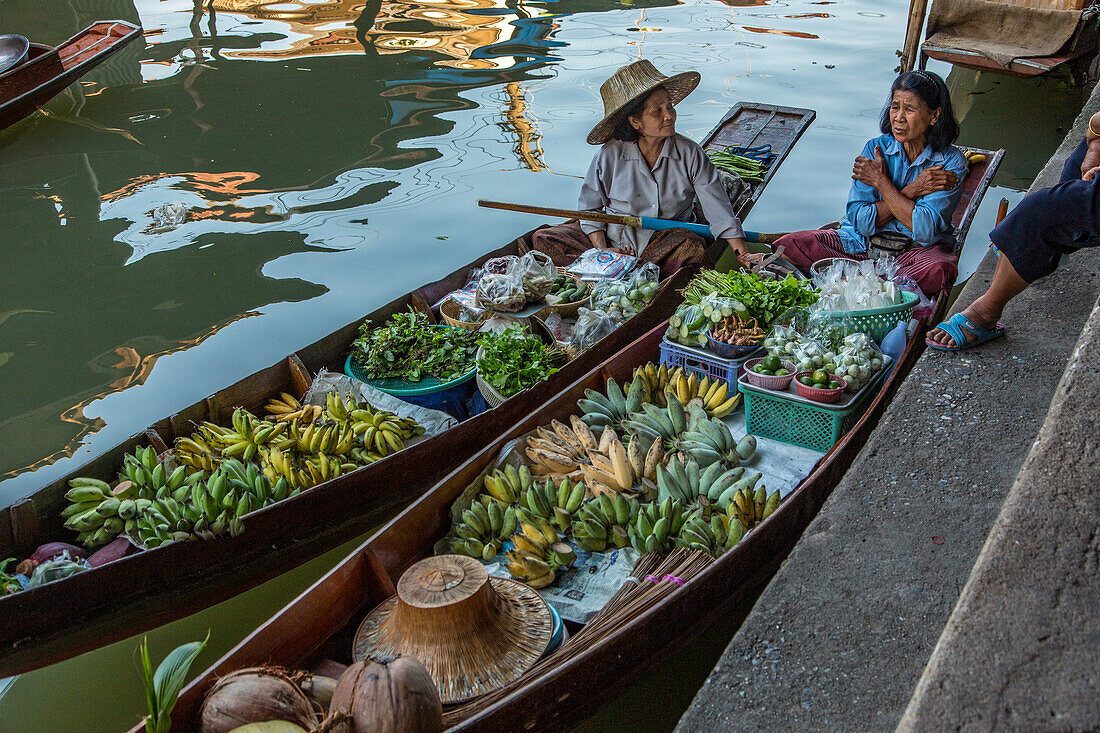 Soziale Interaktion zwischen thailändischen Verkäufern auf ihren Booten auf dem schwimmenden Markt von Damnoen Saduak in Thailand