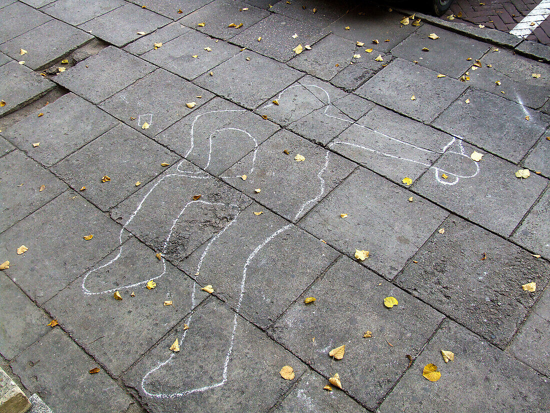 A sidewalk chalk outline of a fallen drunk in the historic Old Town of Vilnius, Lithuania. A UNESCO World Heritage Site.