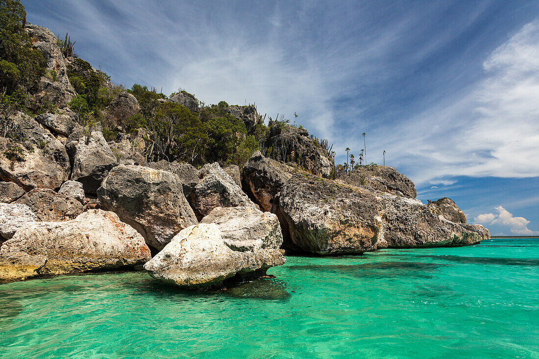 Kristallklares Wasser im Karibischen Meer in der Bucht der Adler, Jaragua National Park, Dominikanische Republik. Wüstenähnliches Klima mit Kaktus- und Dornengestrüppvegetation