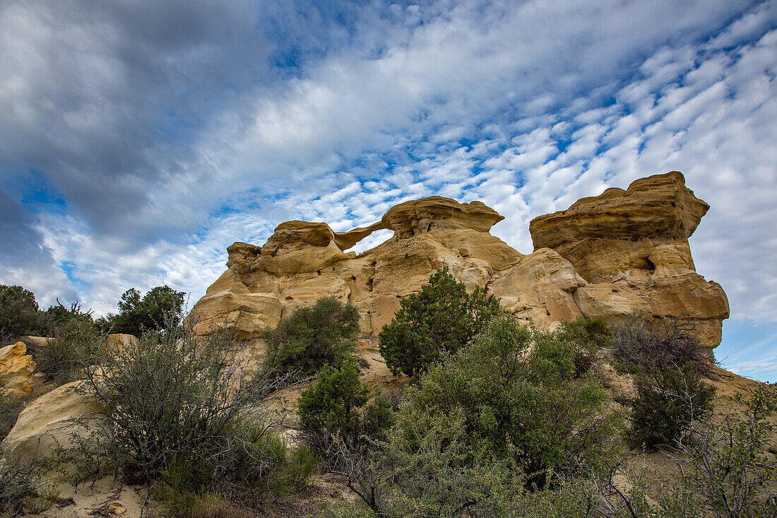 Blue sky and clouds over Graceful Arch in a remote desert near Aztec in northwestern New Mexico.