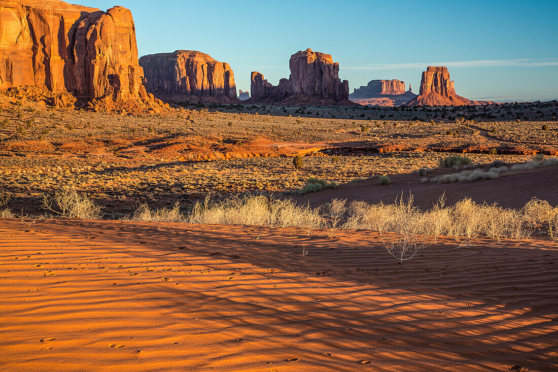 Red sand dunes and sandstone monuments in the Monument Valley Navajo Tribal Park in Arizona.