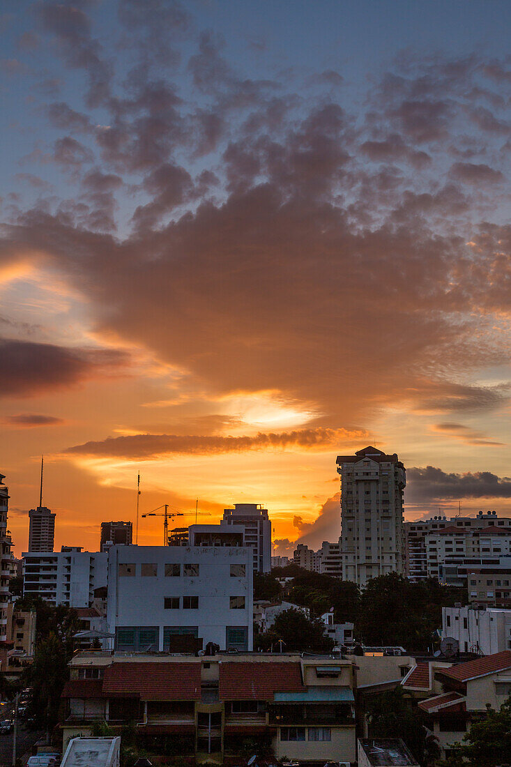 Farbenfrohe Wolken bei Sonnenuntergang über Wohnhäusern im Zentrum von Santo Domingo, Dominikanische Repbulik