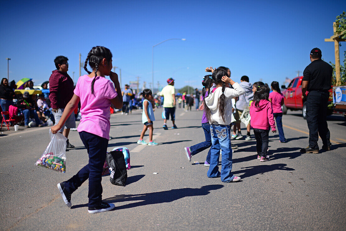 Kids catching candies during morning parade at Navajo Nation Fair, a world-renowned event that showcases Navajo Agriculture, Fine Arts and Crafts, with the promotion and preservation of the Navajo heritage by providing cultural entertainment. Window Rock, Arizona.