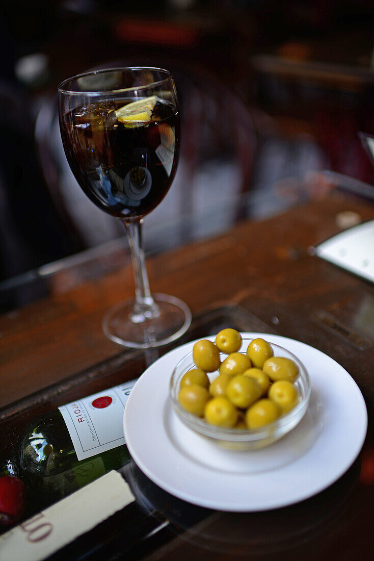 Ein Glas Limonade und grüne Oliven im Restaurant La Bicicleta, Granada, Spanien