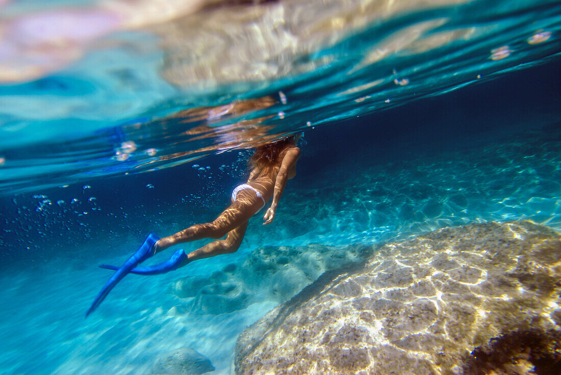 Frau unter Wasser am Strand von Mitjorn auf Formentera, Spanien