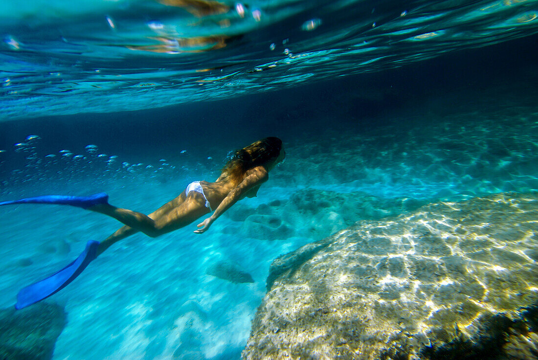 Frau unter Wasser am Strand von Mitjorn auf Formentera, Spanien
