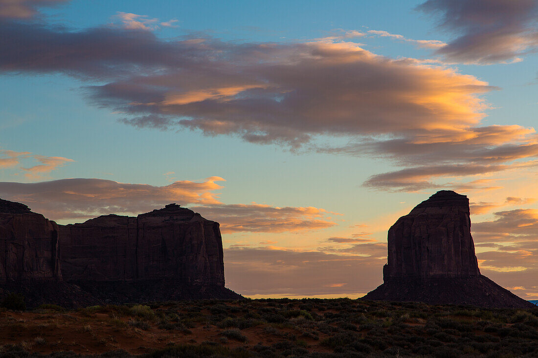 Bunte Wolken über dem Grey Whiskers Butte bei Sonnenuntergang im Monument Valley Navajo Tribal Park in Arizona