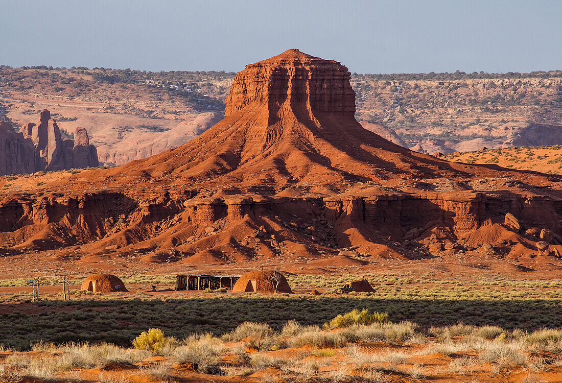 Traditionelle Navajo-Hogans vor der Hub oder Wagon Wheel Butte im Monument Valley Navajo Tribal Park in Arizona