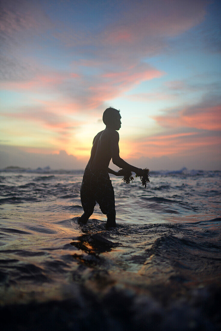 Young local man, who lost many things during the tsunami, feeds the turtles in Hikkaduwa Beach, Sri Lanka