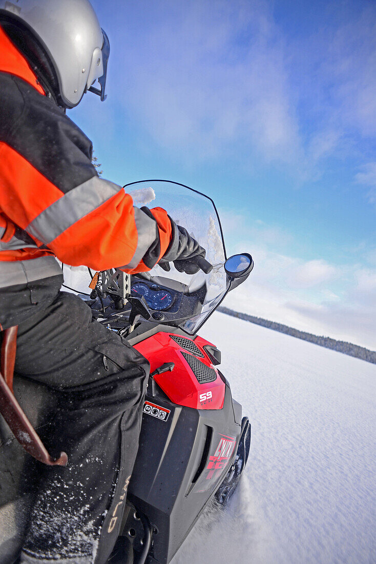Antti, junger finnischer Reiseleiter von VisitInari, fährt mit einem Schneemobil in der Wildnis von Inari, Lappland, Finnland