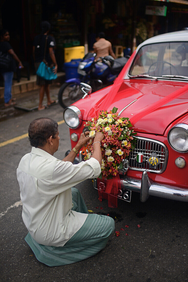 Mann schmückt Hochzeitsauto mit Blumen, Galle, Sri Lanka