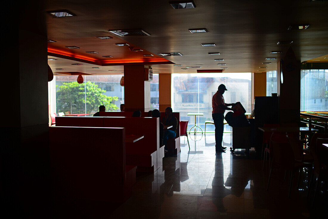 Silhouette of worker cleaning in Burger King, Galle, Sri Lanka