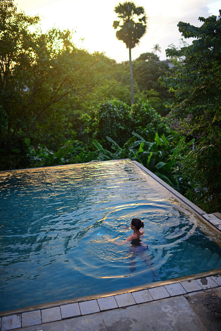 Junge attraktive Frau betritt einen Infinity-Pool im The Dutch House, Galle, Sri Lanka