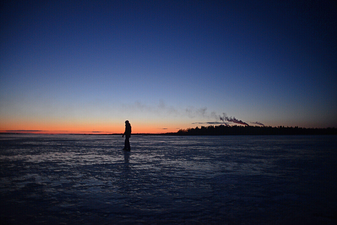 Young woman walking on the frozen waters of the Gulf of Bothnia, Kemi, Lapland.