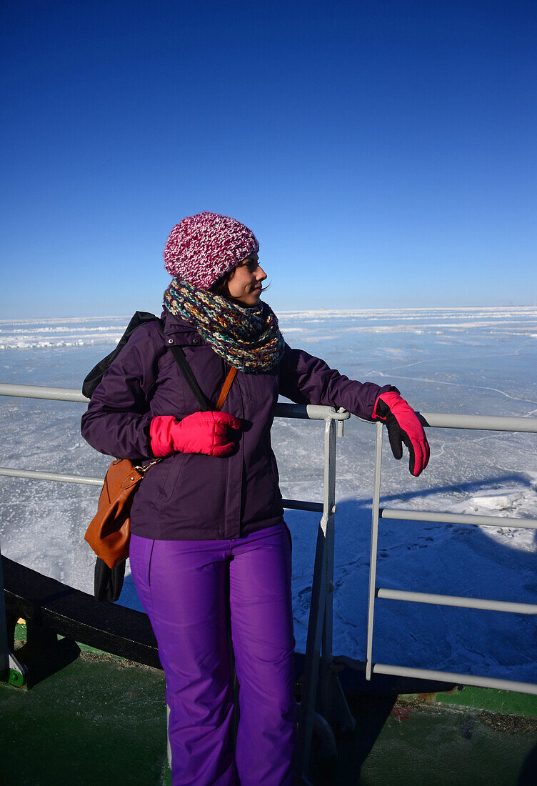 Young woman enjoying Sampo Icebreaker cruise, an authentic Finnish icebreaker turned into touristic attraction in Kemi, Lapland
