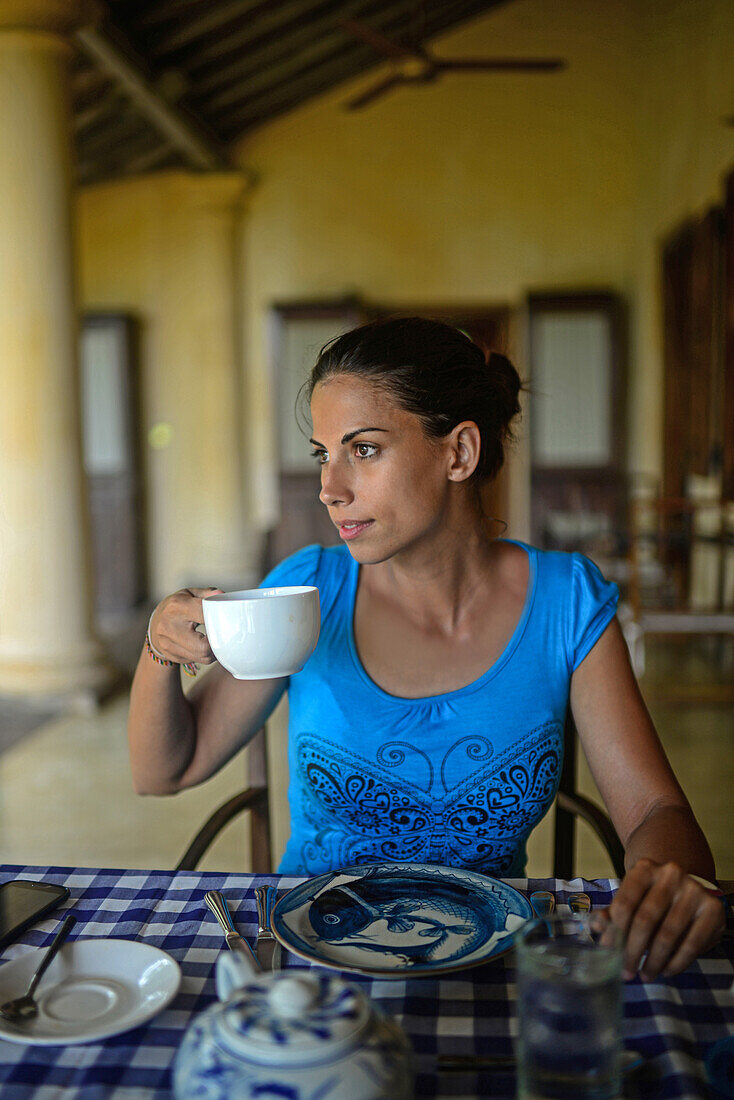 Young attractive woman having breakfast in The Dutch House hotel, Galle, Sri Lanka