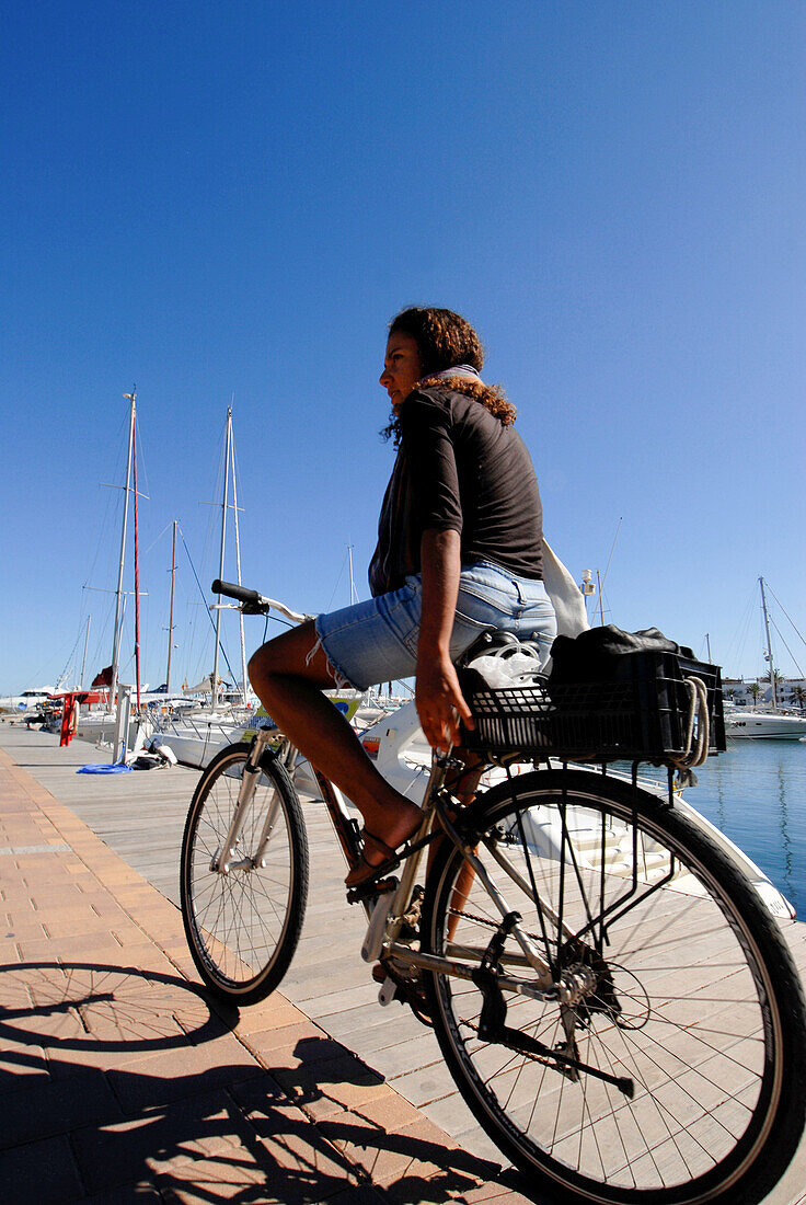 Junge brasilianische Frau auf ihrem Fahrrad, La Savina, Formentera