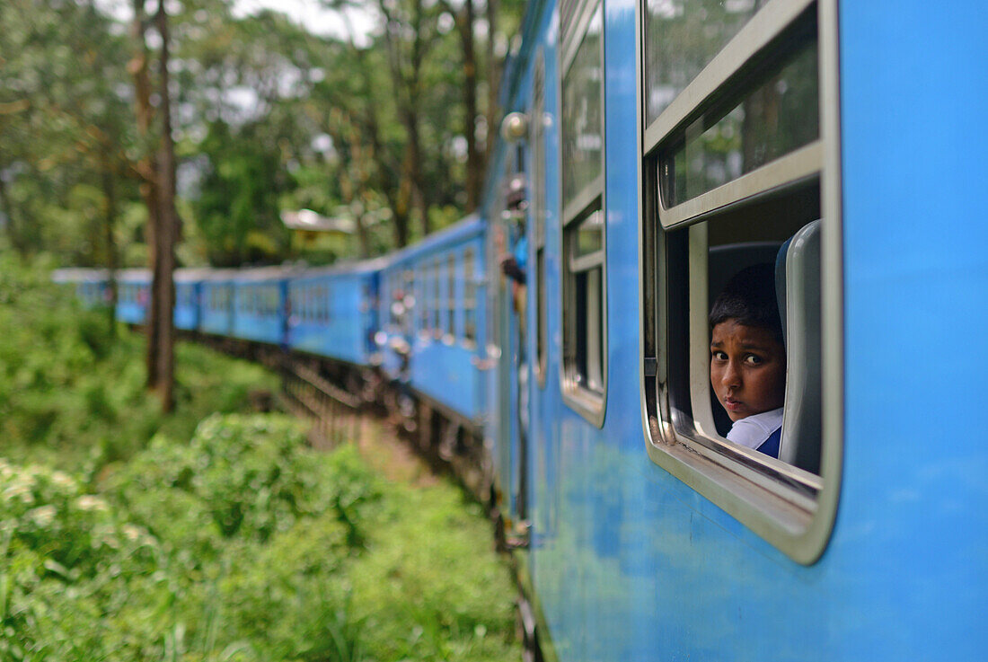 Porträt eines jungen Mannes während der Zugfahrt von Kandy nach Nuwara Eliya, Sri Lanka