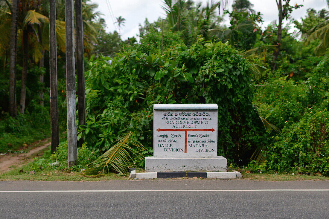 Road development authority sign indicates Galle and Matara Divisions, Ahangama, Sri Lanka