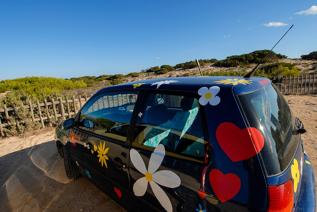 Buntes und blumengeschmücktes Auto am Strand von Levante - Playa de Llevant -, Formentera